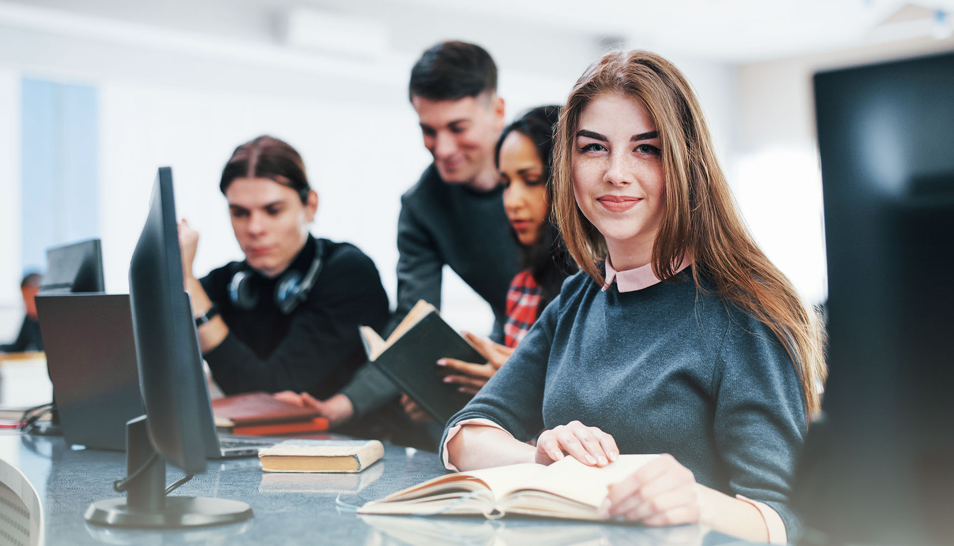 Students studying together in a modern classroom using computers and books during a skill development training session at Ayhan Institute