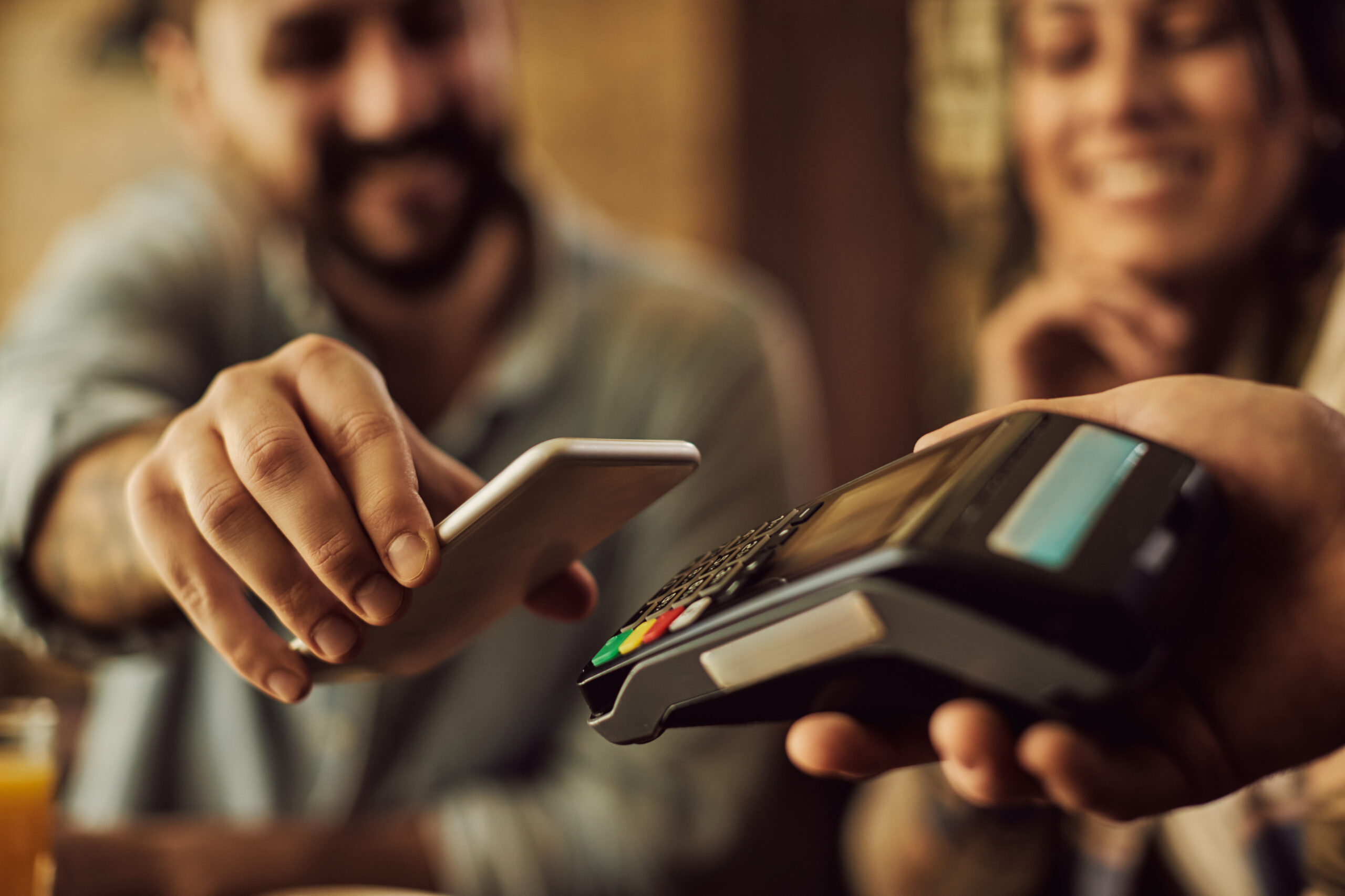 close up of man making contactless payment with smart phone.
